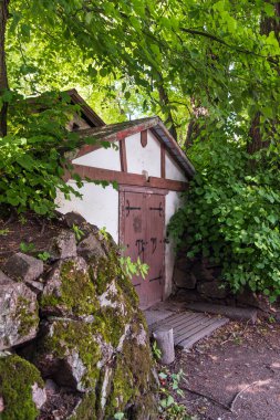 Güzel, işlenmiş demir elementlerle dolu eski bir bina ahşap kapılarda, güzel bir ormanda.