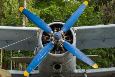 Motorun kompartımanına yakın çekim ve asfaltta güneşli bir günde eski bir uçağın pervanesi.