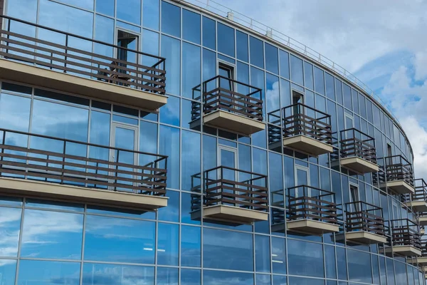 modern high-tech building design, classic balconies against a glass wall. Futuristic appearance and shape of the building.