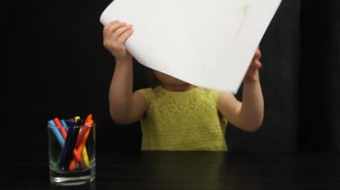 Küçük kız onu kağıt ve başparmak üzerinde çizim gösterir