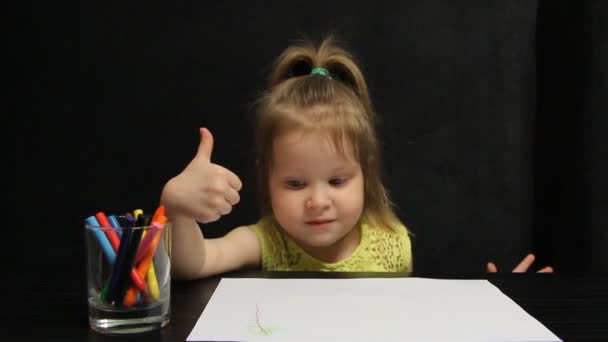 Niña muestra el pulgar hacia arriba mientras dibuja — Vídeo de stock