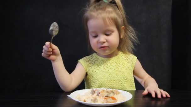 Трехлетняя девочка разговаривает во время еды — стоковое видео