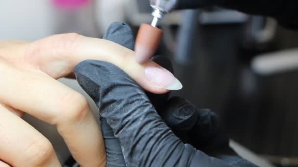 Manicurist is polishing cuticle and skin around nails by drill machine — Stock Video