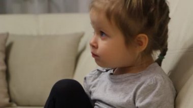 Küçük kız kanepede oturan ve tv izlerken