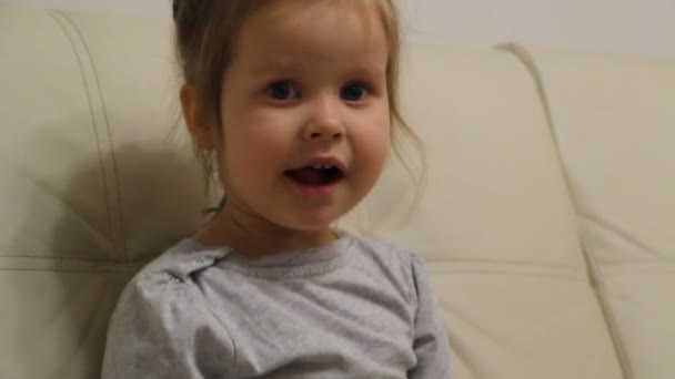 テレビを見ながら緑のリンゴを食べる小さな女の子 — ストック動画