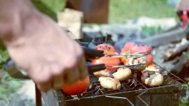 A férfiak kézzel forgatják a zöldségeket a grillen — Stock videók