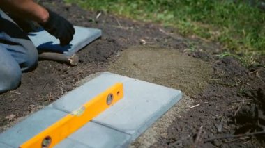 Adam gri bir döşeme serer.