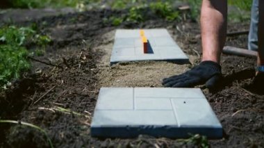 Adam gri bir döşeme serer.