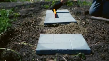 Adam gri bir döşeme serer.