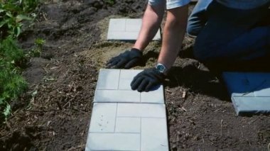 Adam gri bir döşeme serer.