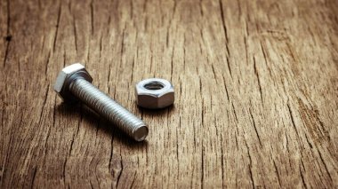 Terk edilmiş ahşap masada civata ve civler.