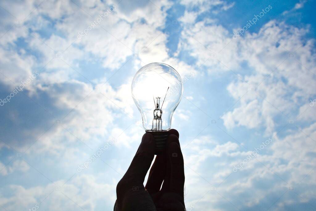 Ceiling lamp in hand on blue sky background