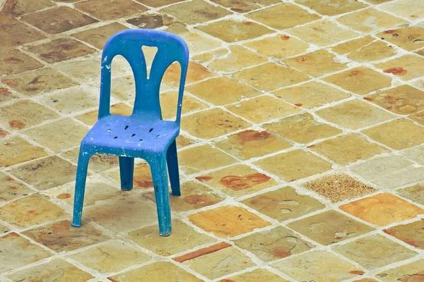 Eski mavi plastik sandalye tuğla zeminde