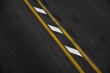 Siyah asfalt üzerinde sarı ve beyaz boya çizgisi. uzay ulaşım arkaplanı