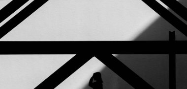 Metal yapı silueti ve binadaki kadınlar.