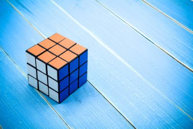 Tayland, Bangkok. 13 Aralık 2017. Mavi ahşap masa arkasında Rubik küpü. Rubik Küpü, 1974 yılında Macar mimar Erno Rubik tarafından icat edildi..