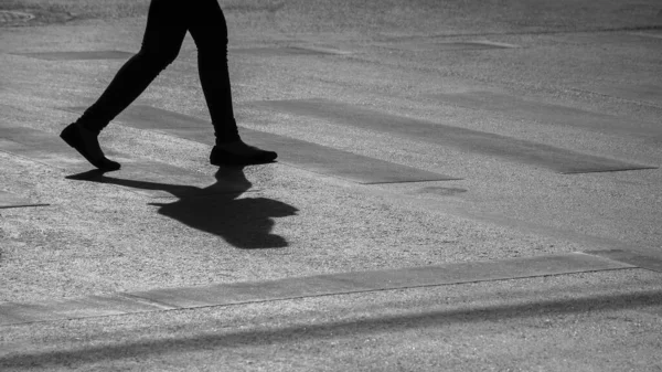 アスファルトの道を歩く一人の女性 モノクロ — ストック写真