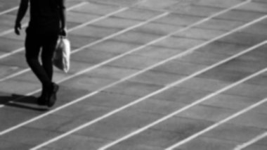 Şehirde kaldırımda yürüyen yalnız bir adam - bulanık tek renkli arka plan