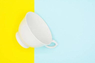 Mavi ve sarı kağıt üzerine beyaz seramik kahve fincanı - arka plan