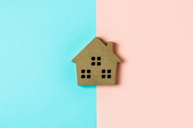 Mavi ve pembe arkaplanda kahverengi ahşap ev simgesi