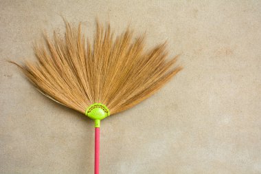 Eski ve kirli beton duvarlara yaslanarak yer tozu temizlemek için kullanılan samandan yapılmış süpürge.