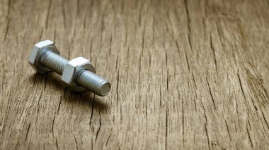 Terk edilmiş ahşap masada civata ve civler.