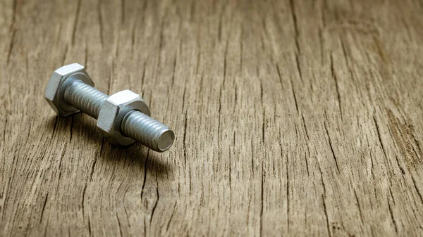 Terk edilmiş ahşap masada civata ve civler.