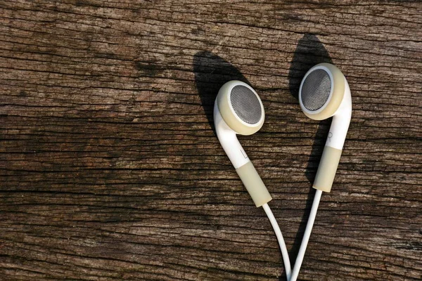 white earphones on old wood background