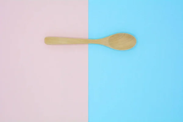 粉色和蓝色背景的木制勺子 — 图库照片