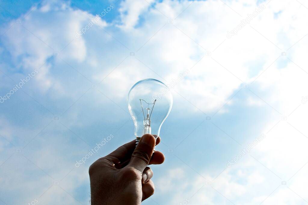 Ceiling lamp in hand on blue sky background