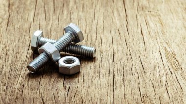 Terk edilmiş ahşap masada civata ve civler.