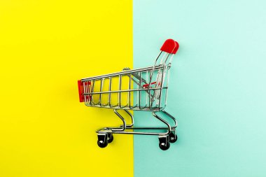 Sarı ve mavi arka planda boş alışveriş arabası. - Reklam ve fotokopi alanı için..