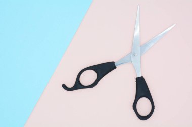 mavi ve pembe kağıt arka planda siyah makas