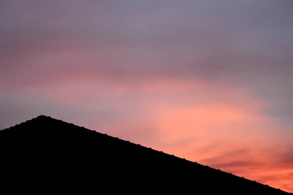 日落前粉红幻想天空的新房子的屋顶轮廓 — 图库照片