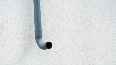 Beyaz duvarda kavisli plastik boru