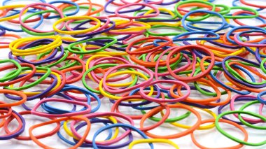 Beyaz arkaplanda izole edilmiş renkli lastik bantlar yığını