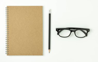 Günlük defteri, kalem ve beyaz arka planda bir gözlük.