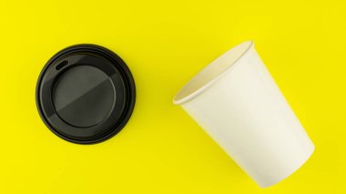 Sarı arka planda paket kağıttan kahve fincanı..