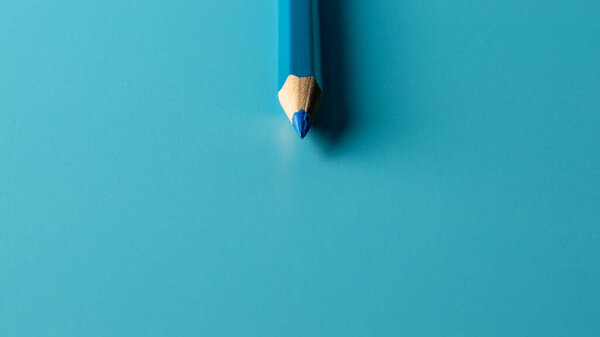 blue crayon pencil on blue paper background. - Business concept.