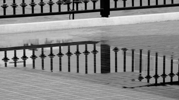 Metallzaun Mit Reflexion Auf Dem Wasser Nach Einem Regentag — Stockfoto