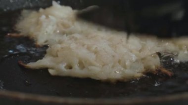 hash browns bir tavada bir spatula ile ters çevrilmiştir