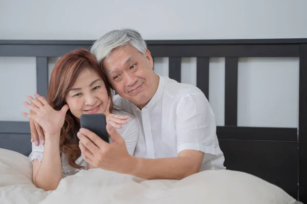 Happy Asian Senior Couple  lifestyle technology device concept,Lovely elderly couple take a selfie with by they smartphone