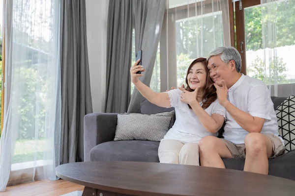 Happy Asian Senior Couple  lifestyle technology device concept,Lovely elderly couple take a selfie with by they smartphone