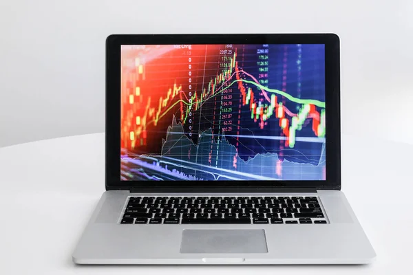 En un portátil de mesa blanca con un gráfico de crecimiento — Foto de Stock