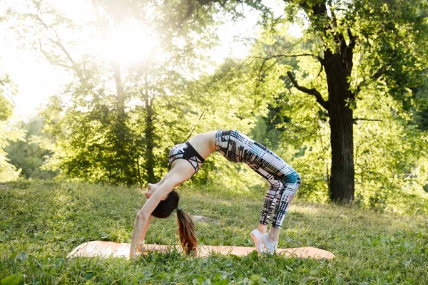 Девушка занимается фитнесом и медитирует в парке города — стоковое фото