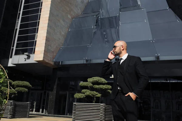 Businessman with a bag near the office talking on the phone — Stock Photo, Image