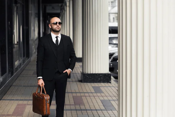 Businessman with a bag near the office talking on the phone — Stock Photo, Image