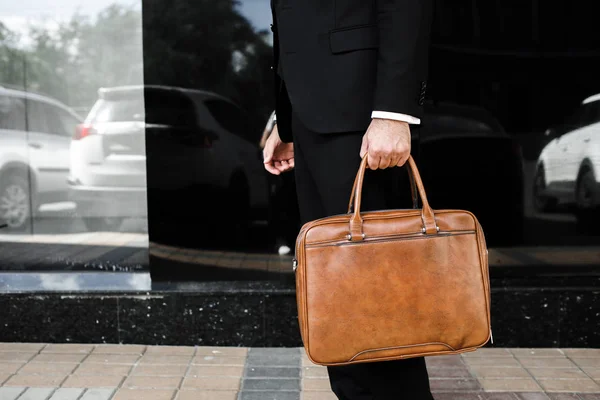 Бизнесмен с сумкой рядом с офисом разговаривает по телефону — стоковое фото