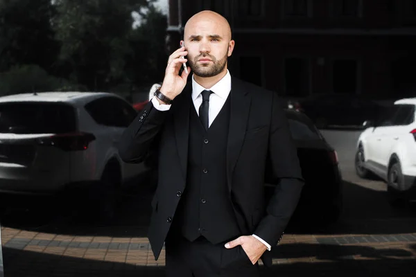 Businessman with a bag near the office talking on the phone — Stock Photo, Image