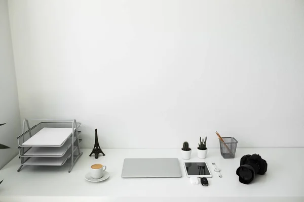 Stół biurowy, na którym laptop, Kawa, tablet, aparat fotograficzny i inne przedmioty — Zdjęcie stockowe